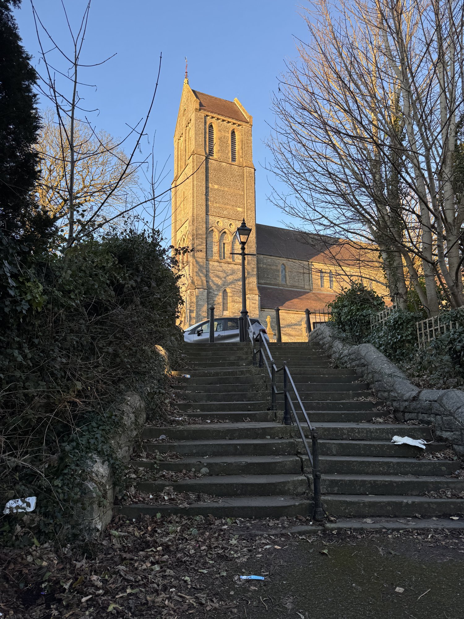 The stone steps up to St Augustine's Church, Penarth, with the tower in golden evening light