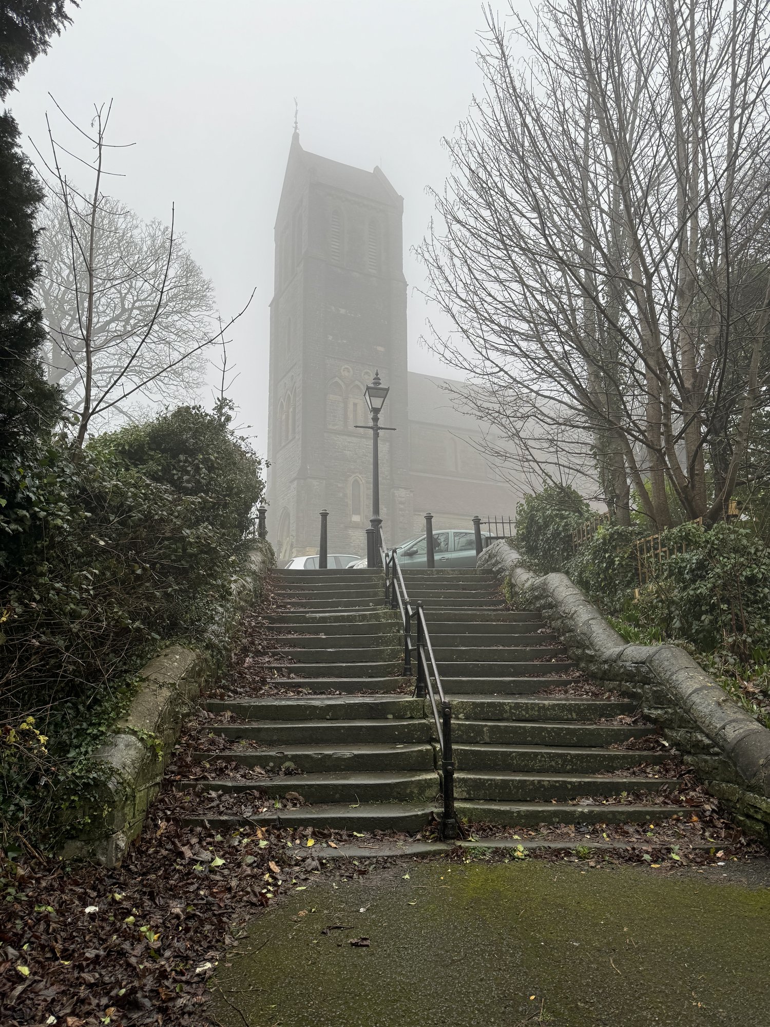 The tower of St Augustine's, Penarth, half-dissolved in fog above the stone steps