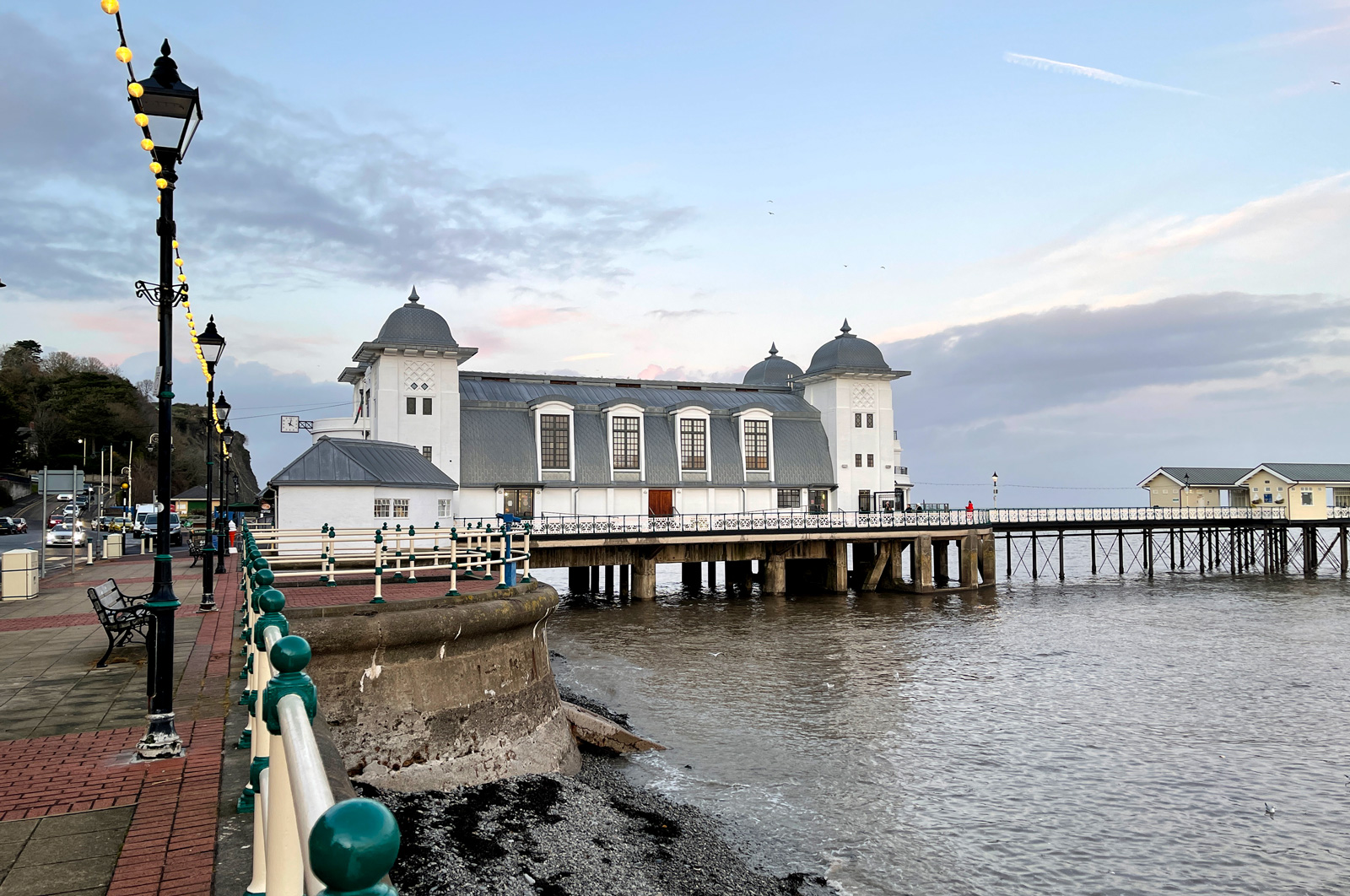 Penarth Pier from the esplanade in the evening, festoon lights along the seafront