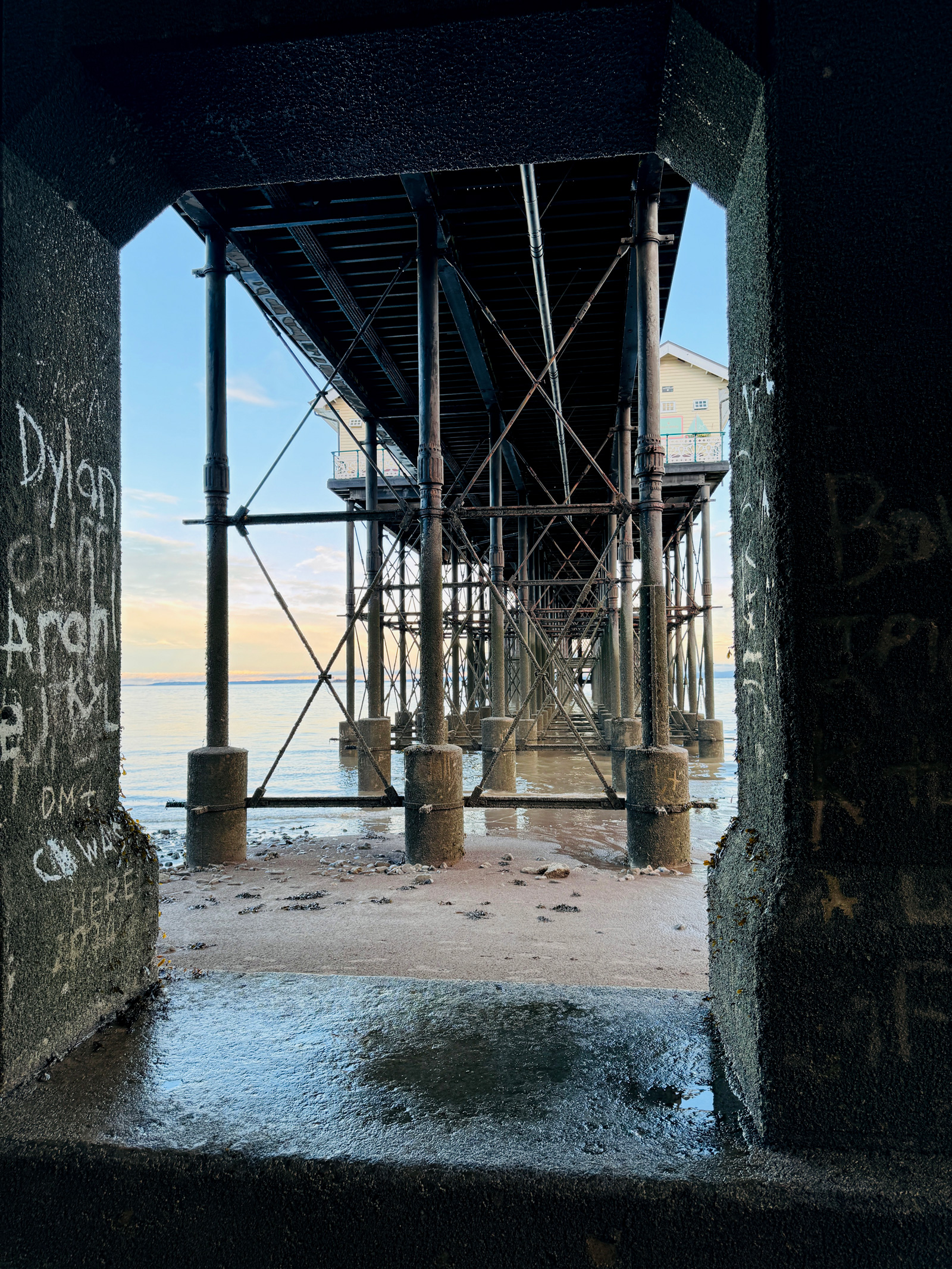 View from below Penarth Pier through iron columns and concrete arch
