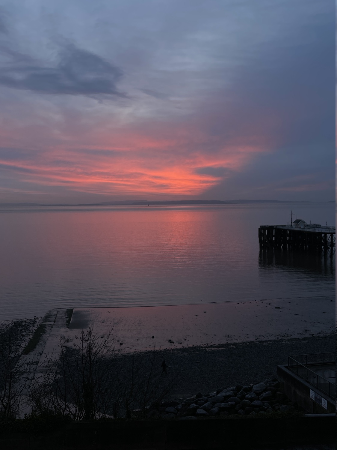 Penarth Pier and beach under a pink winter sunset