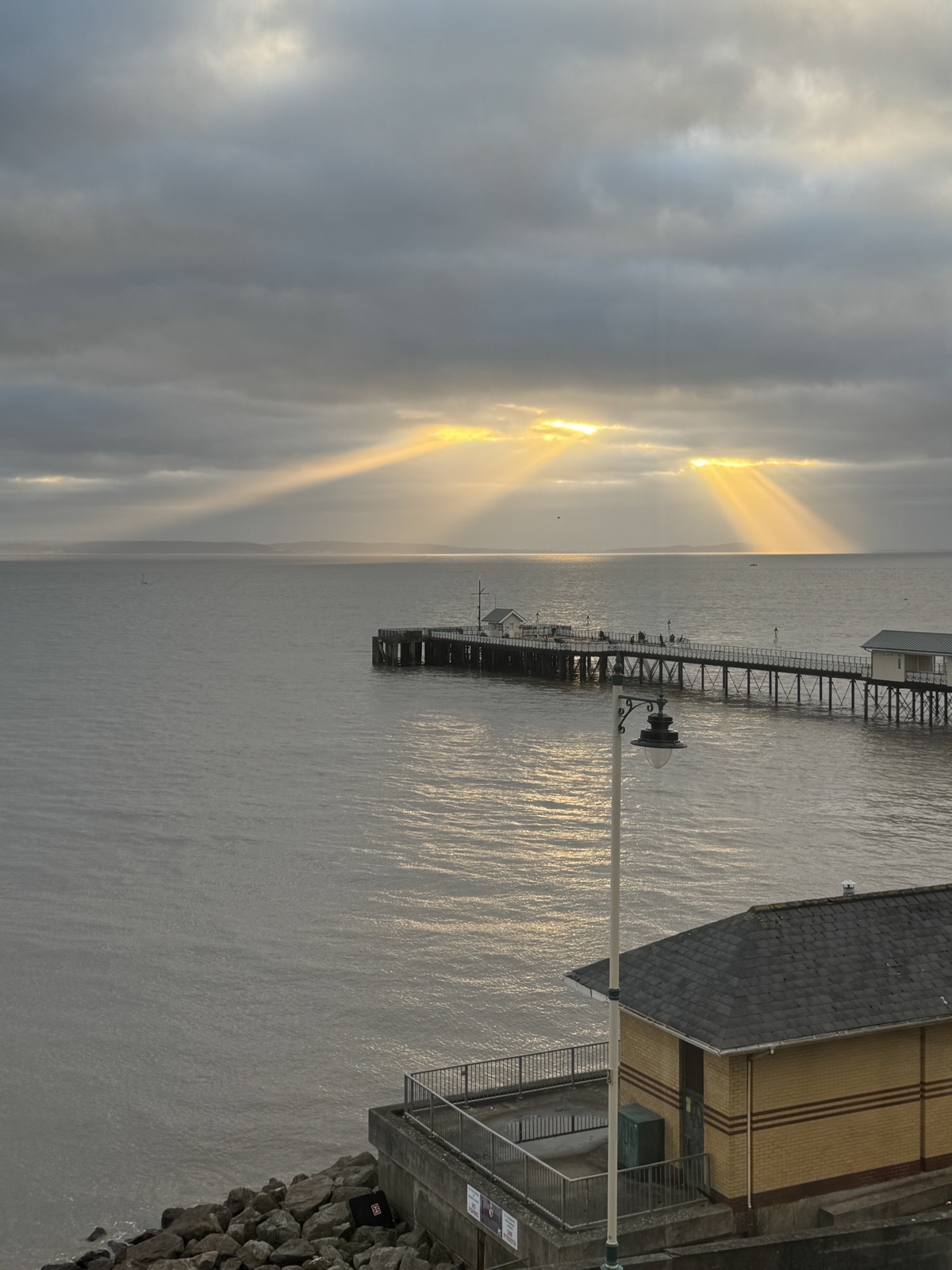 Sun rays over the Bristol Channel behind Penarth Pier