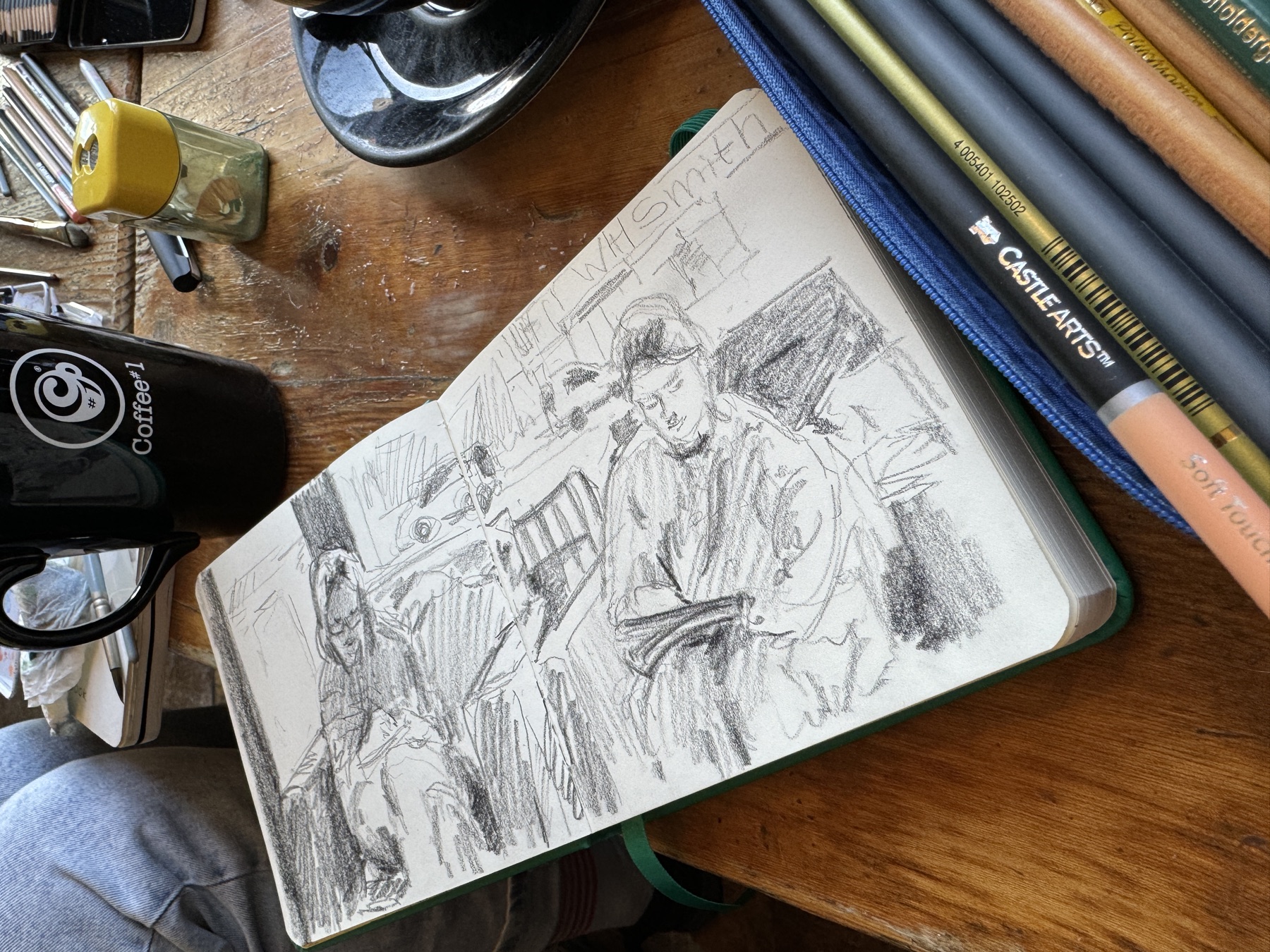 A sketchbook with quick pencil drawings of people in a cafe